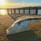 sunsets over the Plym Estuary with a giant leaf bench by the waters side. Plymouth public art
