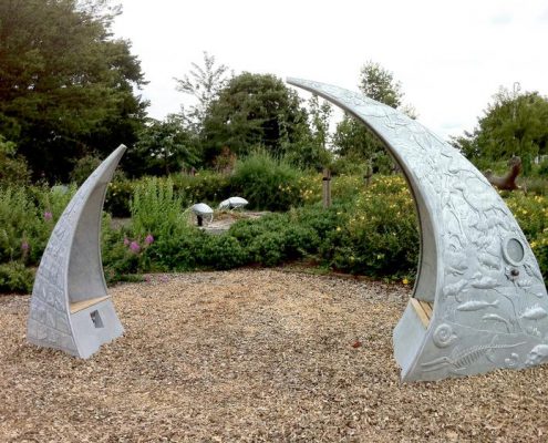 Storytelling Thrones for Rickley Park School| Milton Keynes | Thrussells Milton Keynes School two metal arched seat with metal relief imagery of local heritage. Mad by Thrussells. Public Art Milton Keynes