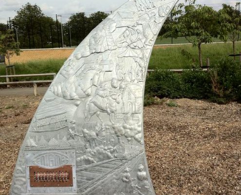 Storytelling Thrones for Rickley Park School| Milton Keynes | Thrussells Milton Keynes School metal arched seat with metal relief imagery of local heritage. Mad by Thrussells. Public Art Milton Keynes