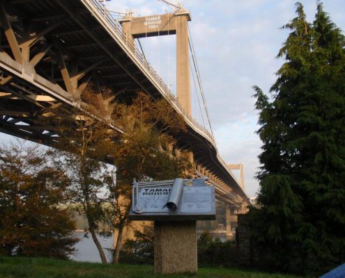Tamar Bridge Drawing Board, celebrating the designers of the bridge | Saltash, Cornwall | Thrussells Beneath a large suspension bridge is a sculptural drawing board sculpture which celebrates the bridge designers. Made by Thrussells. Public Art Cornwall
