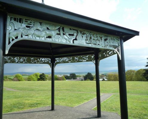 Launceston Park Heritage Bandstand, depicting the towns history and culture | Launceston, Cornwall | Thrussells bandstand structure with relief metal imagery in park land. Made by Thrussells. Public Art Cornwall