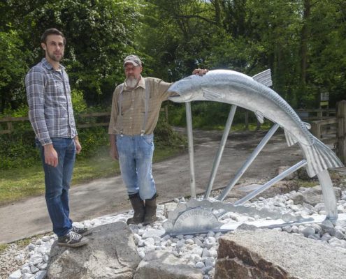 Thomas and Gary pose with the Camel Trail Salmon Sculpture made with St Tudy Primary School. Made by Thrussells. Poley Bridge, Cornwall. Public Art Cornwall