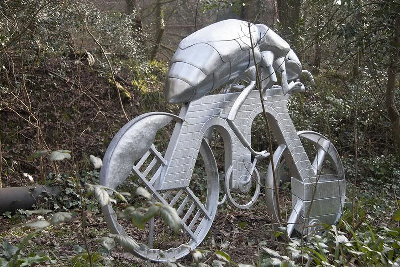 'Beetle On A Bike' feature sculpture on the Plym Valley Heritage Trail metal sculpture of a giant beetle riding a bike. Plymouth public art