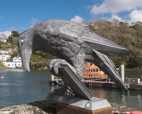 metal bird sculpture holding a book. Public Art Cornwall