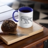 Two tone white and navy blue mug with Thrussells grey bird with coffee and cake