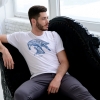 Man sitting with white t-shirt with Thrussells blue bird